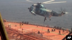 资料照片：伊朗海军2023年4月28日发布的视频显示，伊朗海军陆战队员在阿曼湾扣押油轮时从直升机上降落到 “优势甜”号上。(美联社照片)
