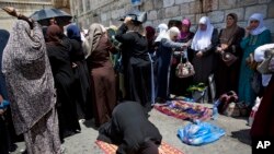Palestinians women pray at the Lion's Gate following an appeal from clerics to pray in the streets instead of inside the Al Aqsa Mosque compound, in Jerusalem's Old City, Tuesday, July 25, 2017.