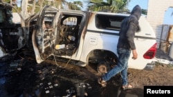 A Palestinian inspects a vehicle where employees from the World Central Kitchen aid group were killed in an Israeli airstrike in central Gaza, April 2, 2024.