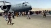 Stotine ljudi trči duž piste pored američkog vojnog transportnog aviona C-17, dok se on kreće na Međunarodnom aerodromu "Hamid Karzai" u Kabulu 16. avgusta 2021. (Foto: AP)