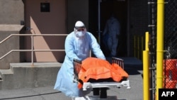 A medical staffer moves the body of a coronavirus victim from the Wyckoff Heights Medical Center to a refrigerated truck, in Brooklyn, New York, April 2, 2020.