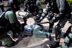 Riot police officers use pepper spray as they detain a protester during a demonstration at the Central District in Hong Kong, Nov. 13, 2019.
