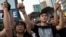 Student protesters gesture outside the Golden Bauhinia Square, venue of the official flag-raising ceremony for celebrations of China's National Day in Hong Kong, October 1, 2014.