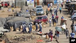 Zimbabwe riot police patrol the streets near a fruit and vegetable market full of people despite a lockdown in an effort to curb the spread of the coronavirus, in Harare, Zimbabwe, April 7, 2020.