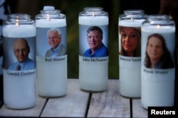 Candles representing the slain journalists of Capital Gazette sit on display during a candlelight vigil held near the Capital Gazette, the day after a gunman killed five people inside the newspaper's building in Annapolis, Maryland