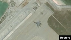 FILE - Satellite imagery shows what the CSIS Asia Maritime Transparency Initiative describes as the deployment of several new weapons systems, including a J-11 combat aircraft, at China’s base on Woody Island in the Paracels, South China Sea, May 12, 2018. (Courtesy CSIS Asia Maritime Transparency Initiative/DigitalGlobe)