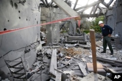 Policajac ispituje oštećenja na kući pogođenoj raketom u Mišmeretu, centralni Izrael, 25. marta 2019.