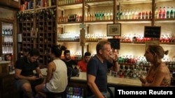 People sit at a bar amid the spread of the coronavirus disease in Athens, Greece, Aug. 1, 2020. 