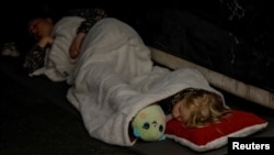 A girl sleeps with her toy as she takes shelter with her family inside a metro station during a Russian military attack in Kyiv, Ukraine, on June 1, 2024.