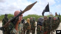 FILE - Al-Shabab fighters display weapons as they conduct military exercises in northern Mogadishu, Somalia, Oct. 21, 2010.