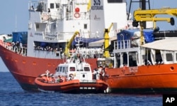 An Italian Coast Guard boat approaches the Aquarius ship as migrants are being transferred, in the Mediterranean Sea, June 12, 2018.