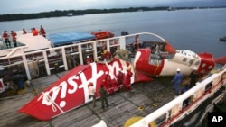 Crew members of Crest Onyx ship prepare to unload parts of AirAsia Flight 8501 from a ship at Kumai port in Pangkalan Bun, Jan. 11, 2015.