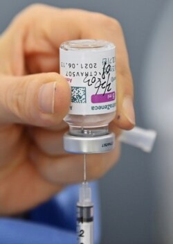 FILE - A nurse fills a syringe with the AstraZeneca COVID-19 vaccine at a health care center in Seoul, Feb. 26, 2021.