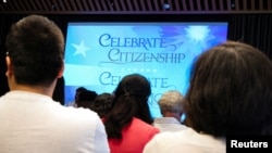 Građani prisustvuju ceremoniji naturalizacije u gradskoj biblioteci Njujorka, 2. jula 2024. 