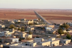 FILE - A Kurdish village stands deserted in Kobani after the Islamic State fighters took control of the area, Oct. 7, 2014.