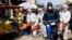 Workers wearing protective gear spray disinfectant as a precaution against the coronavirus, at the main market in Gaza City, March 19, 2020. 