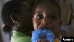 Seorang ibu yang hidup dengan HIV bersama bayinya yang tidak terinfeksi HIV di Jayapura. (Foto: Reuters/Oka Barta Daud)