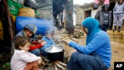 Suriyalik qochqin ayol qochqinlar lagerida bolalari uchun ovqat pishirmoqda