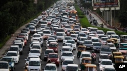 Heavy traffic moves at dusk in New Delhi, India. Car Free Day is an effort to ease long traffic waits and improve air quality.