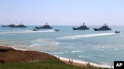 This handout photo released April 22, 2021, by Russia's Defense Ministry, shows Russian navy ships preparing to unload troops during drills in Crimea, a peninsula Russia annexed from Ukraine in 2014. 