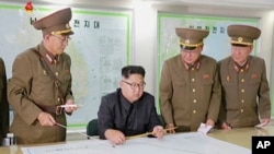 This image made from video of an Aug. 14, 2017, still image broadcast in a news bulletin, Aug. 15, 2017, by North Korea's KRT shows North Korean leader Kim Jong Un receiving a briefing in Pyongyang.