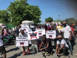Protesters hold posters that say Lage Pye Ou (step on it), the theme of the protest, Oct 13, 2019. (Photo: M. Vilme/VOA Creole)