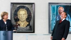In this Tuesday, July 10, 2007 file photo, predecessor German Chancellor Gerhard Schroeder, right, laughs during a speech by German Chancellor Angela Merkel, left. (AP Photo/Markus Schreiber, File)
