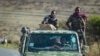 FILE - Ethiopian government soldiers ride in the back of a truck on a road near Agula, north of Mekele, in the Tigray region of northern Ethiopia, May 8, 2021.