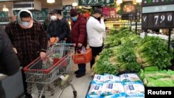 រូបឯកសារ៖ មនុស្ស​ពាក់ម៉ាស​ដើរ​ទិញ​ទំនិញ​នៅ ផ្សារ​ទំនើប​មួយ​នៅ​ទីក្រុង Wuhan ខេត្ត Hubei ប្រទេសចិន កាលពី​ថ្ងៃទី២៦ ខែមករា ឆ្នាំ២០២០។