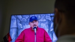 A man watches a televised national address by Nicaraguan President Daniel Ortega, at his home in Managua, June 23, 2021.