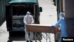 Mortuary workers push a coffin of a person who died at a nursing home during the coronavirus disease (COVID-19) outbreak in Leganes Madrid, Spain, April 2, 2020. 