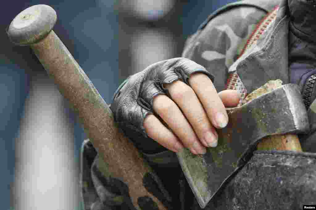 A female member of a "Maidan" self-defense unit stands guard in front of the Ukrainian parliament building in Kyiv, April 15, 2014.