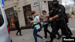 FILE - Law enforcement officers detain journalists in Minsk, Belarus, July 28, 2020. Belarus has cracked down hard on news media, deporting some foreign journalists and revoking others' accreditation.
