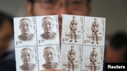 资料照片：有人手持中国前副总理习仲勋的纪念邮票。习仲勋是中国领导人习近平的父亲。(2013年10月15日)