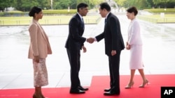 2023年5月19日，日本广岛举行的七国集团峰会开幕前，英国首相里希·苏纳克（左二）和他的妻子阿克沙塔·穆尔蒂（左一）在广岛和平纪念公园受到日本首相岸田文雄（右二）和妻子岸田裕子（右一）的欢迎。