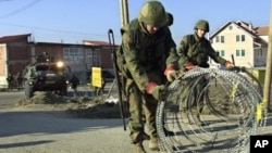 Pripadnici KFOR-a postavljaju blokade na putu koji vodi do Prištine, 18. mart 2004