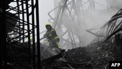 Український рятувальник працює на місці обстрілу безпілотником будівлі складу в Бориспільському районі Київської області 20 грудня 2024 р. Genya SAVILOV/AFP