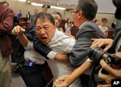 FILE - Pro-democracy lawmaker Wu Chi-wai, center, scuffles with security guards at the Legislative Council in Hong Kong, May 11, 2019.