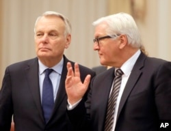 German Foreign Minister Frank-Walter Steinmeier, right, and French Foreign Minister Jean-Marc Ayrault talk ahead of their meeting with Ukrainian officials in Kiev, Feb. 22, 2016. Germany and France are pushing for Ukraine to move ahead with reforms needed in order to implement the year-old Minsk peace agreement.