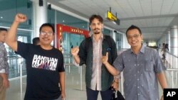 American journalist Philip Myrer Jacobson, center, poses with his Indonesian lawyers at Cilik Riwut Airport in Palangkaraya, Indonesia, Jan. 31, 2020.
