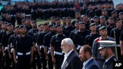 FILE - Fathi Hamad, Gaza's Hamas interior minister, second right, reviews honor guards during a graduation ceremony of Hamas security officers in the northern Gaza Strip, April 2, 2014.