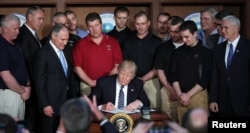 US President Donald Trump reacts after signing an executive order eliminating Obama-era climate change regulations at the Environmental Protection Agency in Washington, March 28, 2017.