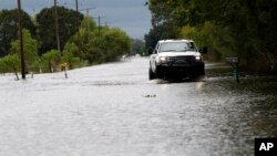 Badai Harvey bergerak ke pedalaman dan membawa hujan lebat ke Louisiana, seperti terlihat banjir menggenangi jalanan di kota Iowa, Louisiana, Rabu (30/8). 