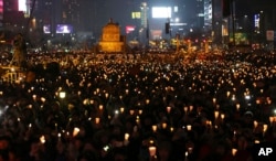 South Korean protesters hold candles during a rally calling for South Korean President Park Geun-hye to step down in Seoul, South Korea, Nov. 26, 2016.