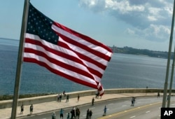 FILE - The U.S. flag waves outside the newly opened U.S. Embassy, overlooking Havana's seaside boulevard, the Malecon in Cuba, Aug. 14, 2015.