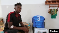 Afrički migrant za koga vladini izvori tvrde da je spašen nakon što je njegov brod potonuo u Sredozemnom moru, nedaleko od obale Tunisa, sedi u prihvatilištu Crvenog krsta u Zarzisu, Tunis, 4. jula 2019.