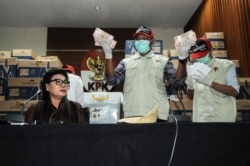Wakil Ketua KPK Basariah Panjaitan bersama para pejabat KPK dengan bukti uang tunai yang disita dari anggota DPR yang ditetapkan sebagai tersangka korupsi, di Jakarta, 17 April 2019. (Foto: AFP)