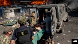 امدادگران در حال کمک به مجروحان پس از حمله موشکی روسیه به یک بازار مواد غذایی - کوستیانتینیوکا، اوکراین.