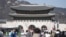 Visitors walk near the Gwanghwamun, the main gate of the 14th-century Gyeongbok Palace, one of South Korea's well known landmarks, in Seoul, South Korea, Thursday, Feb. 27, 2025. (AP Photo/Lee Jin-man)