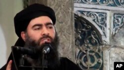 FILE - This image made from video posted on a militant website July 5, 2014, purports to show the leader of the Islamic State group, Abu Bakr al-Baghdadi, delivering a sermon at a mosque in Iraq.